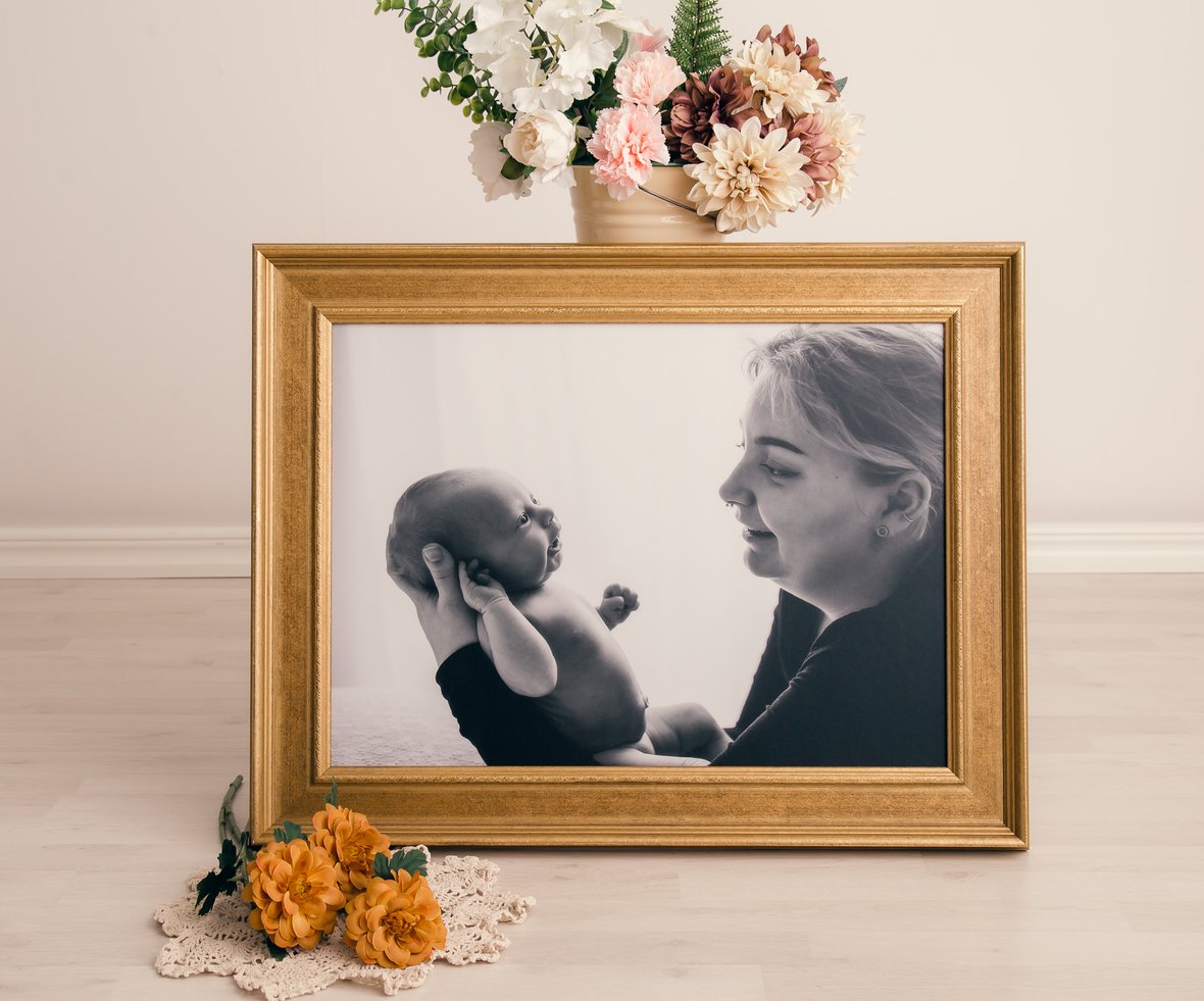 Familjebild vid nyföddfotografering där bebisen ler gulligt